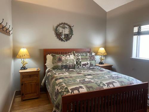 a bedroom with a bed and two night stands with lamps at Casa Nueva #5 Townhouse With Wifi in Red River