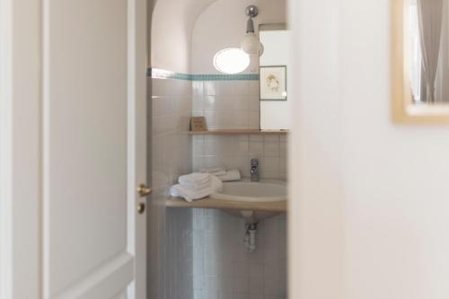 ein Bad mit einem Waschbecken und einem Spiegel in der Unterkunft Il Vicinato, casa vacanza immersa nel cuore dei Sassi in Matera