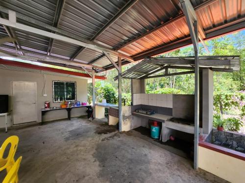 ein leeres Zimmer mit einer Küche und einem großen Fenster in der Unterkunft OYO HOME 90751 Jasura Lodge Kiulu in Tamparuli