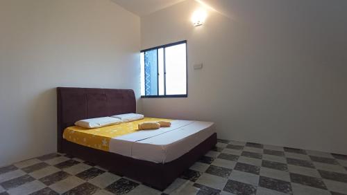 ein Schlafzimmer mit einem Bett in einem Zimmer mit einem Fenster in der Unterkunft OYO HOME 90751 Jasura Lodge Kiulu in Tamparuli