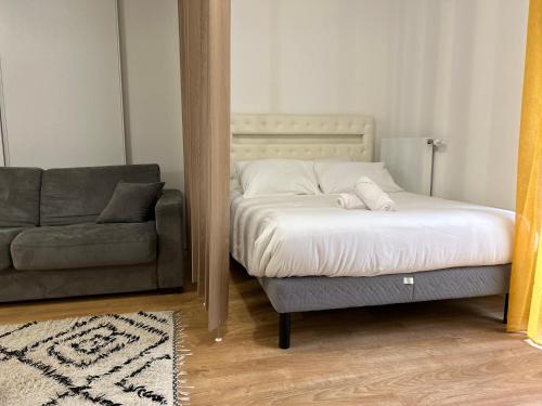 a bedroom with a bed and a couch and a mirror at Le Vestige - Between Paris & DisneyLand - 5min From Train Station in Villiers-sur-Marne
