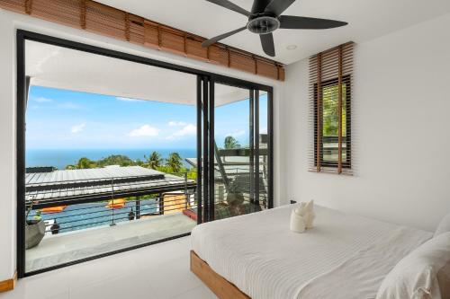a bedroom with a large window with a view of the ocean at Infinity villa 600 M2 sea view in Haad Yao