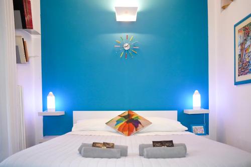 una camera blu con un letto con un orologio sul muro di B&B Arts And Music ad Ancona