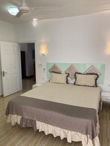 ein Schlafzimmer mit einem großen Bett mit Kissen in der Unterkunft Residence La Colombe in Grand Baie