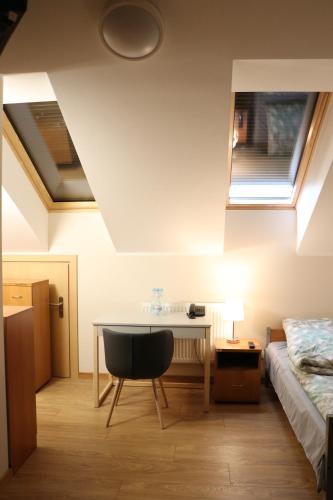 Schlafzimmer mit einem Schreibtisch, einem Bett und einem Fenster in der Unterkunft Dom Studenta PANS - Akademik, Hostel in Przemyśl