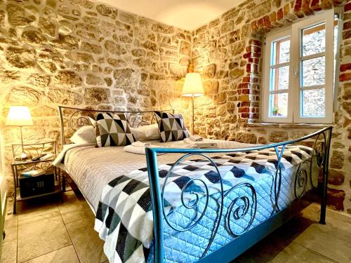 a bedroom with a bed in a room with stone walls at City Rooms Šibenik in Šibenik