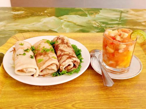 a plate of sandwiches and a drink on a table at Bois vert Hôtel in Abomey