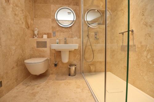 een badkamer met een douche, een toilet en een wastafel bij BY THE BEACH, spacious apartment in Saint Merryn