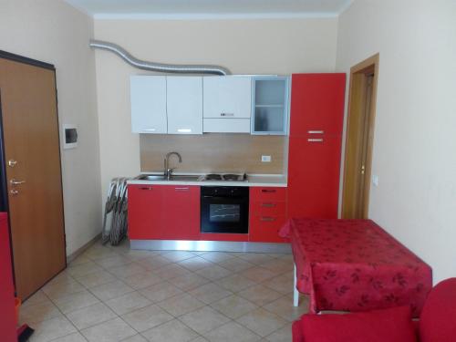 a small kitchen with red cabinets and a red table at Ada Home in Sanremo