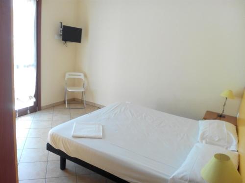 a white bed in a room with a window at Ada Home in Sanremo