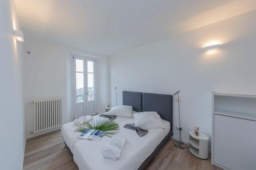 ein Schlafzimmer mit einem weißen Bett mit einer Pflanze darauf in der Unterkunft Casa Brambilla in Cissano
