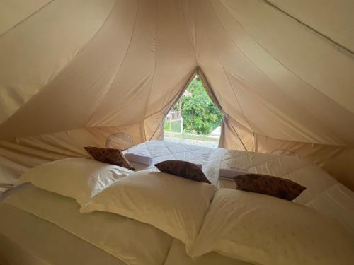 a white bed with pillows in a tent at Tangkahan Eco Glamping 