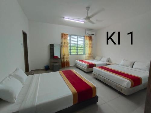 a bedroom with two beds and a kitt sign on the wall at KARAK INDAH HOMESTAY in Karak