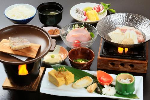 a table topped with plates of food and bowls at Lakeland Hotel Mizunosato in Fujikawaguchiko