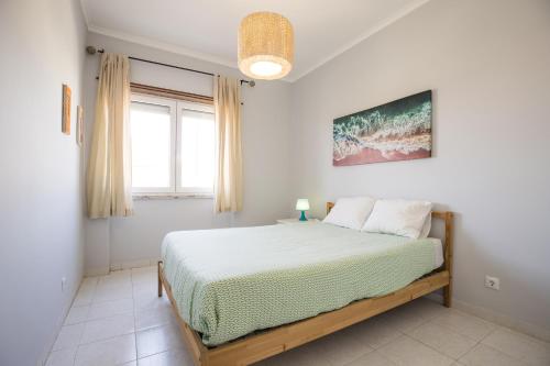 Schlafzimmer mit einem Bett und einem Fenster in der Unterkunft Hoso Apartments T1 in Costa da Caparica