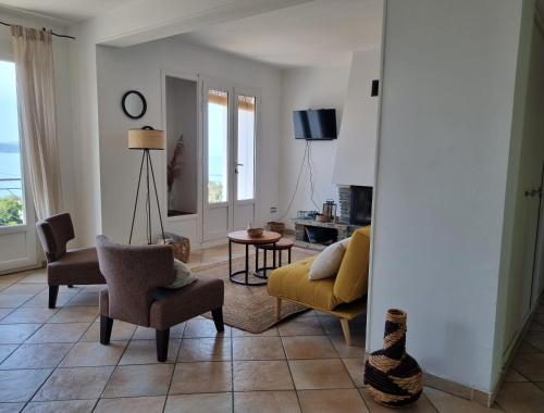 d'un salon avec un canapé et des fauteuils jaunes. dans l'établissement Cap en Corse, à Farinole