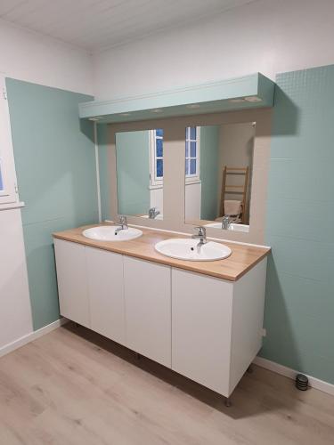 La salle de bains est pourvue de 2 lavabos et d'un miroir. dans l'établissement Le Patio de la Madone, à Le Givre