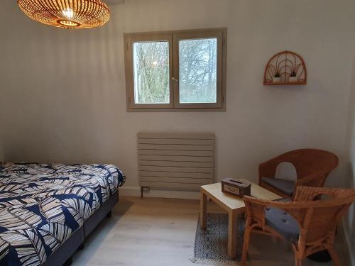 - une chambre avec un lit, une table et une chaise dans l'établissement Le Patio de la Madone, à Le Givre