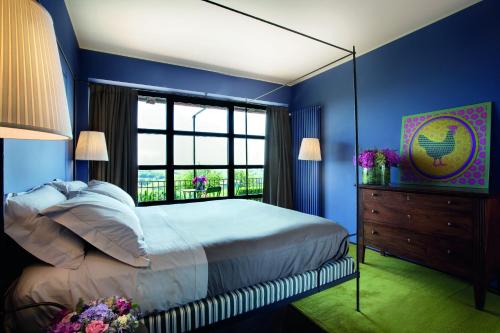 a blue bedroom with a large bed and a window at B&B Puntodivista in Chieri