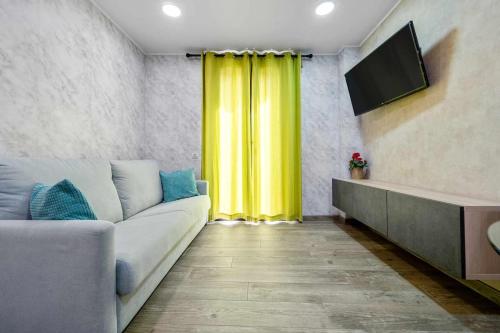 ein Wohnzimmer mit einem Sofa und einem gelben Vorhang in der Unterkunft Apartments Lilia Reus in Reus