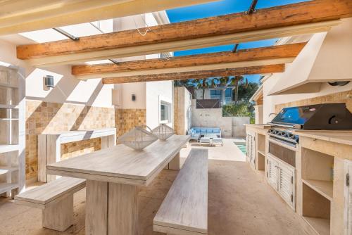een grote keuken met een houten tafel en banken bij Luxury Villa with panoramic sea views in Sol de Mallorca