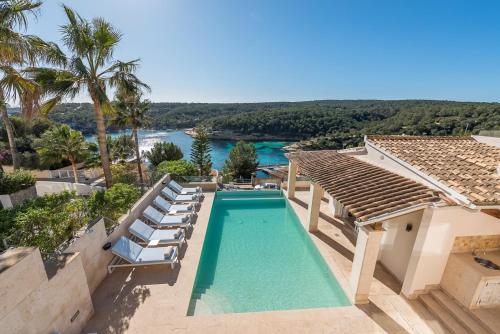 a swimming pool with chairs and a house at Luxury Villa with panoramic sea views in Sol de Mallorca