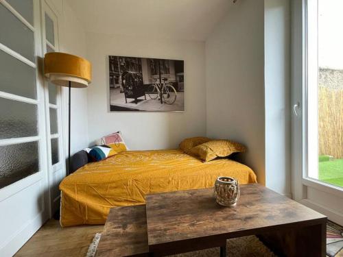 - une chambre avec un lit et une table devant dans l'établissement Republique garden, à Dijon