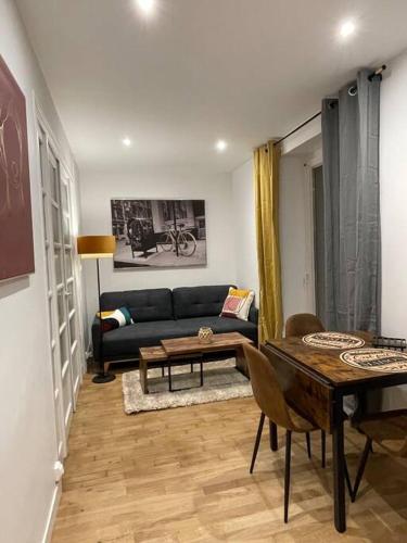 un salon avec un canapé et une table dans l'établissement Republique garden, à Dijon