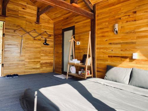 een slaapkamer met een bed in een houten muur bij May Home Tà Xùa in Bắc Yên