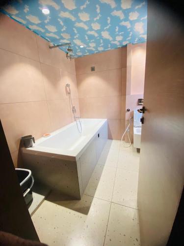 y baño con bañera y techo azul. en Glampeco Villa, en Lonavala