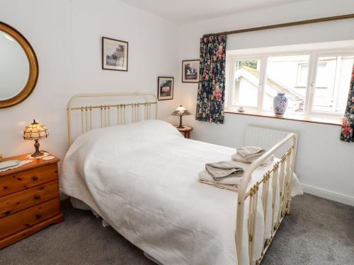 um quarto com uma cama e uma janela em Barnstead em Pooley Bridge