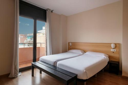 una camera con un letto e una grande finestra di Barcelona Apartment Villarroel a Barcellona