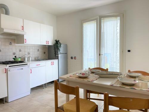 een keuken met witte kasten en een tafel met stoelen bij PRESTIGE - Premium Villas in Giulianova