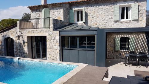 une maison avec une piscine devant une maison dans l'établissement Mougins Mas lumineux vue sur le village, à Mougins