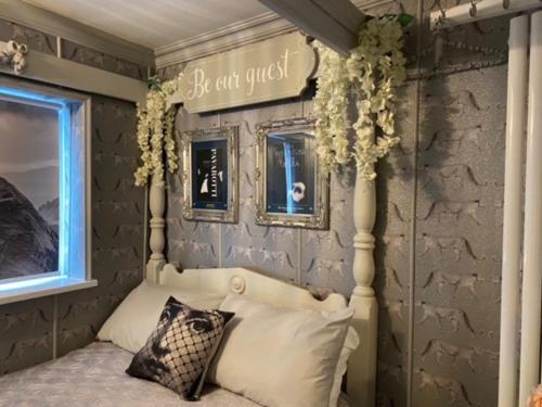 a bedroom with a bed with a sign on the wall at 23 Riverside Cottage, Llangollen in Llangollen