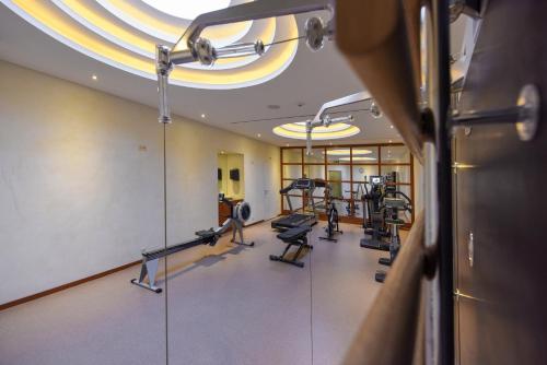 a gym with treadmills and machines in a room at Cresta Palace Celerina in Celerina