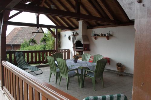 a patio with a table and chairs on a deck at La Maison de Vacances in Nothalten