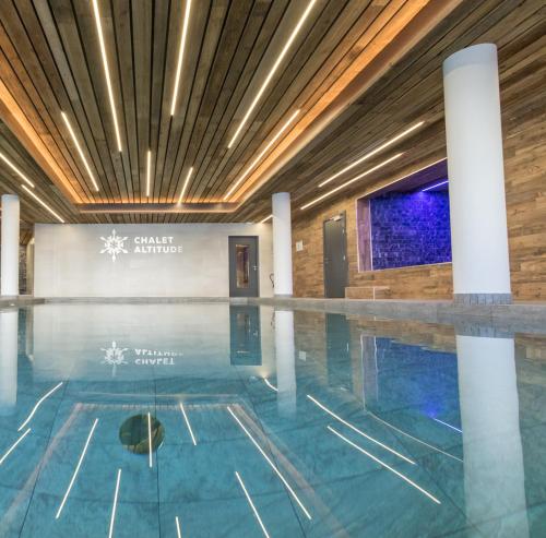 a swimming pool in a building with a swimming pool at Travelski Home Premium - Résidence Chalets Altitude & Ours 5 stars in Arc 2000