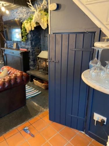 a kitchen with a blue door in a room at 23 Riverside Cottage, Llangollen in Llangollen