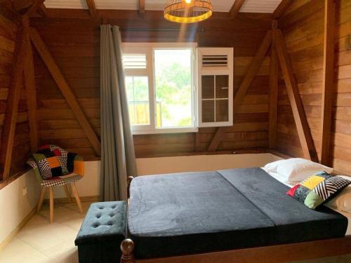 - une chambre avec un lit bleu et une fenêtre dans l'établissement Ti Kay Paradise, à Sainte-Anne