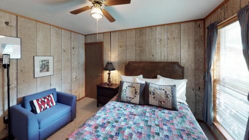 ein Schlafzimmer mit einem Bett und einem blauen Stuhl in der Unterkunft Casa Rio On Oro Fino With High Speed Wifi in Red River