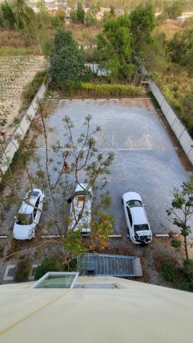 two white cars parked in a parking lot at Rangh Place in Ban Map Samet Daeng