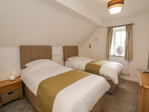 a bedroom with two beds and a window at Dove Meadows House in Buxton