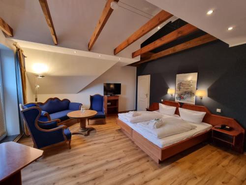 um quarto com uma cama, uma mesa e cadeiras em Hotel Osterkrug em Husum