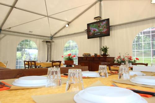 un comedor con una mesa con platos blancos en Borgo Caiano Country Inn, en Caiano