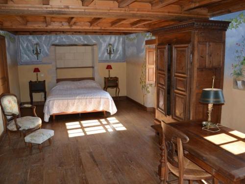 Manoir de Danigny في Saint-Martin-des-Entrées: غرفة نوم بسرير وطاولة ومكتب