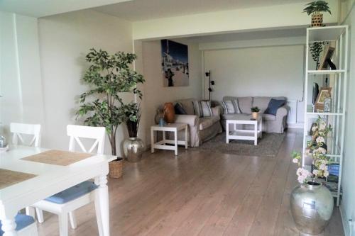a living room with a couch and a table at Have a nice stay! - Souterrain The Freesia in Noordwijk