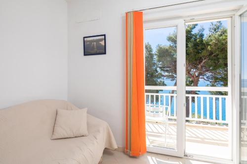 - un salon avec un canapé et une porte coulissante en verre dans l'établissement Aqua Vista Apartments, à Lokva Rogoznica