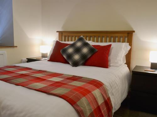 ブリクサムにあるRockfish Cottageのベッドルーム1室(大型ベッド1台、赤い枕付)