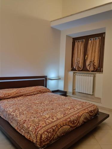 a bedroom with a bed and a window with curtains at Il palazzetto "fori porta" in Vitorchiano